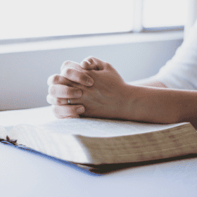 woman praying and reading the Bible and learning the best way to build your faith