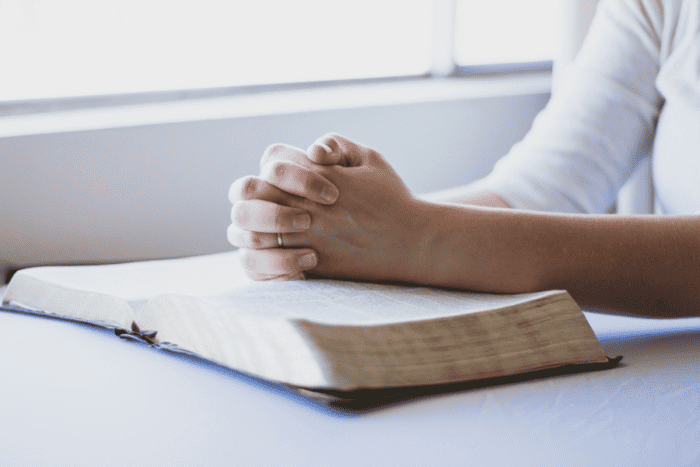 woman praying and reading the Bible and learning the best way to build your faith